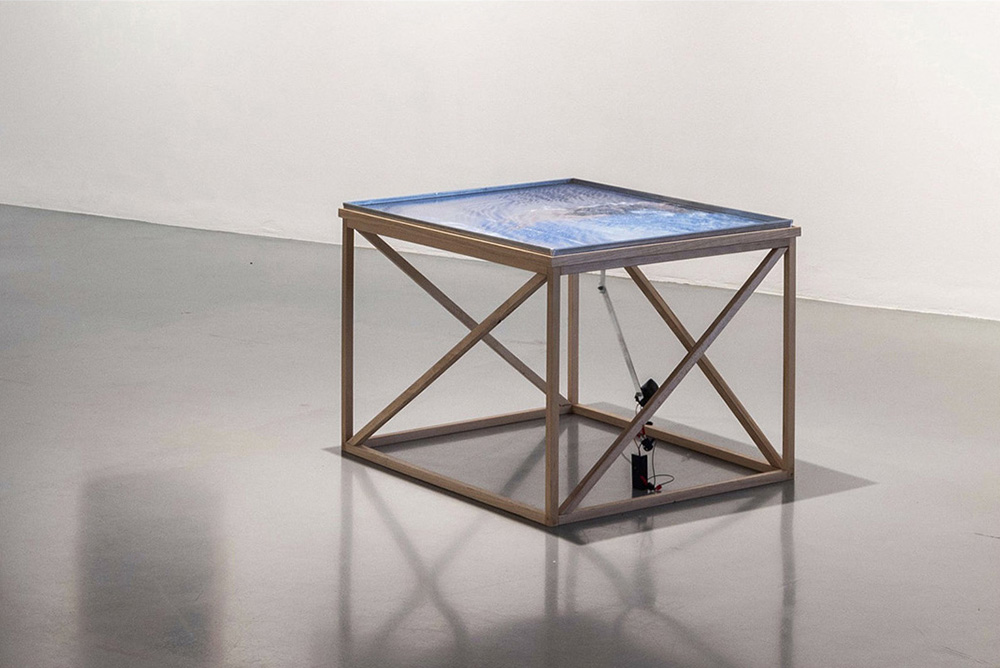 Claudia Amatruda, Tank n. 1, “Good Use of My Bad Health”, 2024,
vasca in alluminio cm 60x80x2, acqua distillata, stampa adesiva in PVC, base in legno di faggio, sistema di vibrazione elettronico a batteria, cm 50x80x60